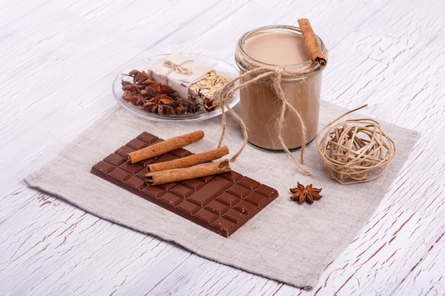 brown detox coctail with cinnamon sticks and chocolate lie on the table