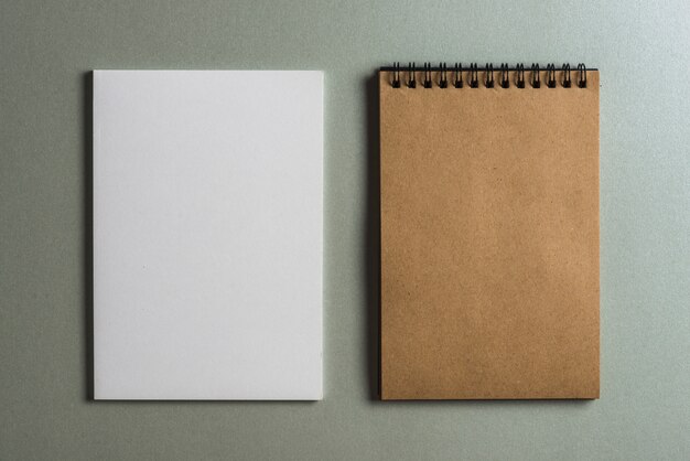 Brown diary and blank white page against colored background