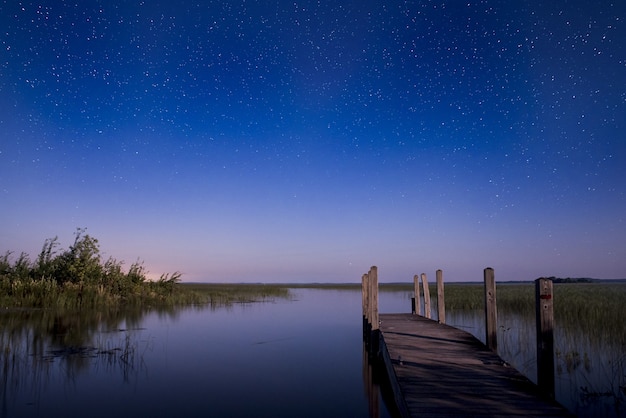 Brown dock in body of water during sunrise