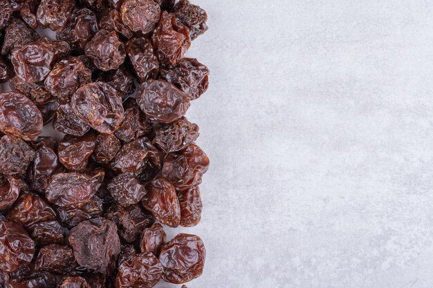 Brown dried cherries isolated on concrete surface