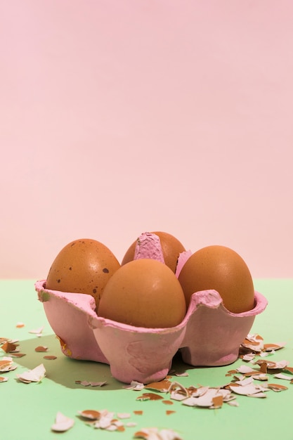 Brown eggs in rack with broken shell on green table