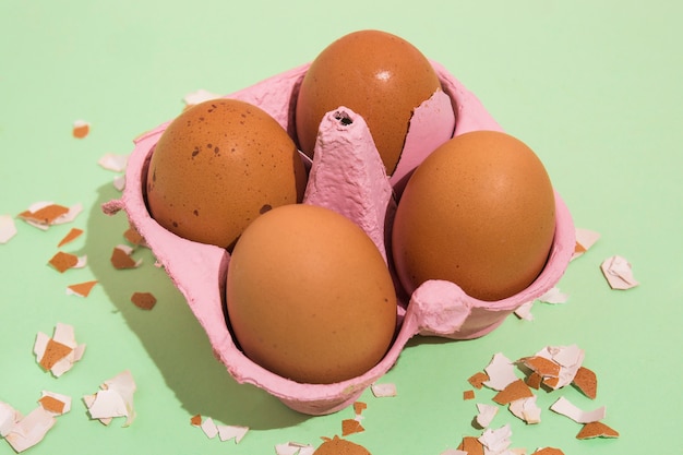 Brown eggs in rack with broken shell on table