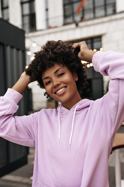 Free Photo | Brown-eyed charming curly brunette woman in purple hoodie ...