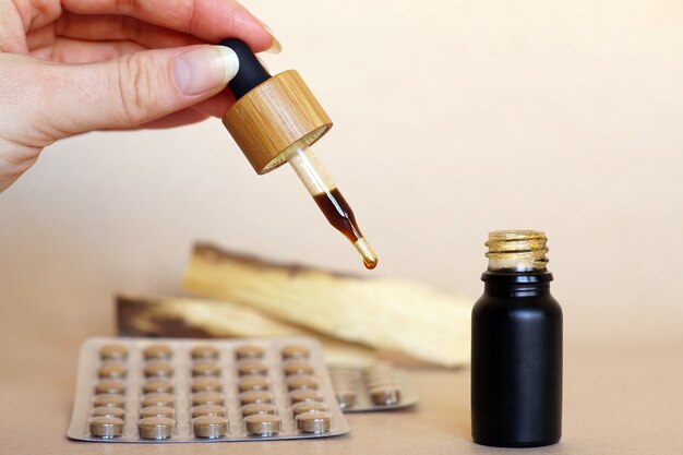 Brown natural medicine in a small bottle with a pipette