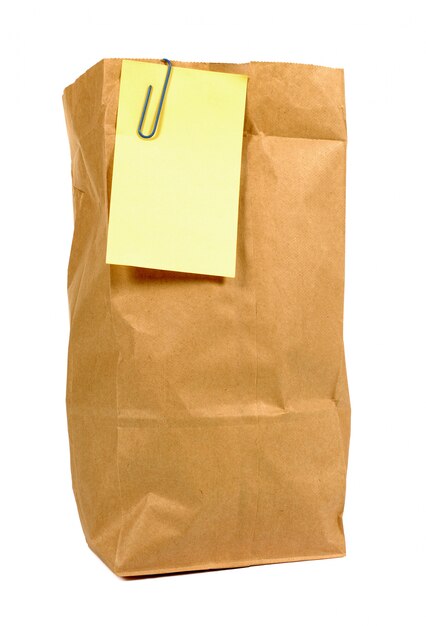 Brown paper lunch bag with yellow post it note 