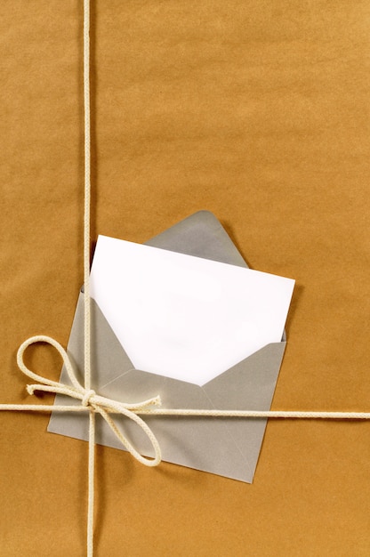 Brown paper parcel with envelope and blank message card