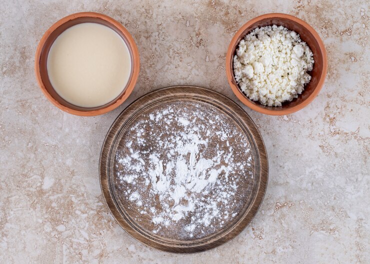 मुफ़्त फोटो a brown plate of flour and a clay bowl of cottage cheese