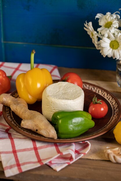 Brown platter with cheese, pepper and ginger inside