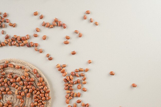 Brown raw beans in a platter on concrete.