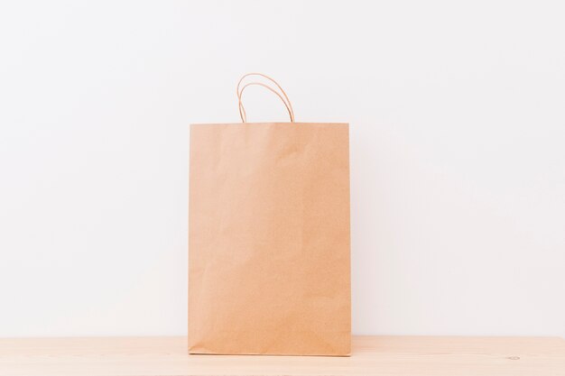 Brown shopping bag on wooden surface