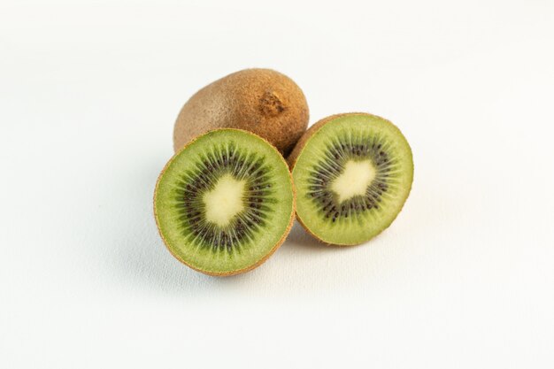 Brown sour kiwis sliced lined isolated on the white surface