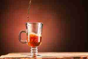 Free photo brown splashes out drink from cup of tea on a brown wall