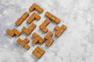 Free photo brown sugar cubes on concrete ,top view