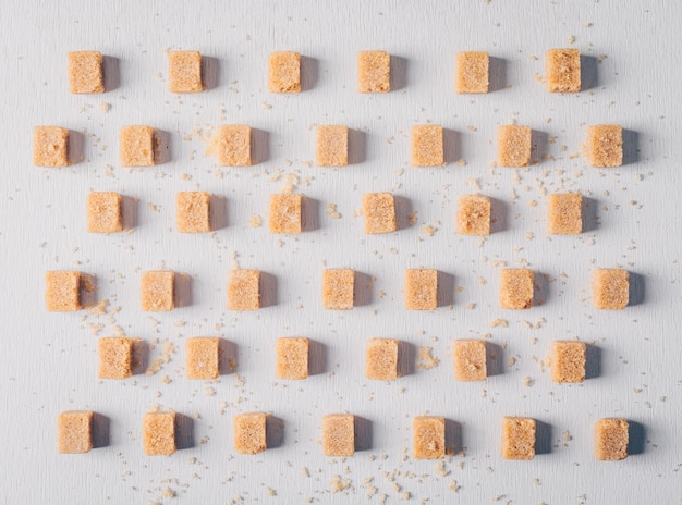 Free photo brown sugar cubes lined up. flat lay.