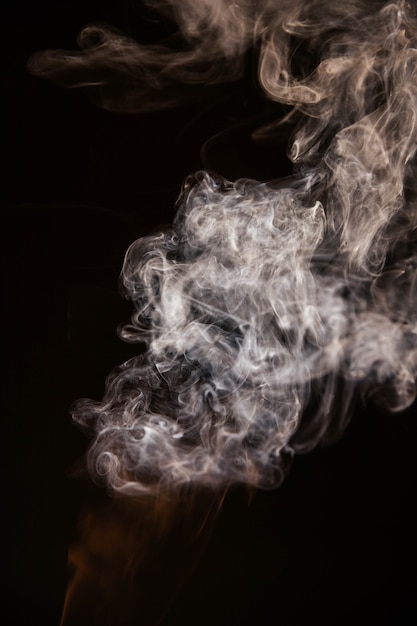 Foto gratuita brown fumo ondulato su sfondo nero