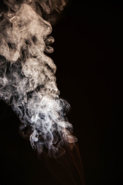 Foto gratuita brown fumo ondulato su sfondo nero