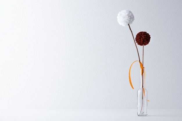 Brown and white pom poms in vase