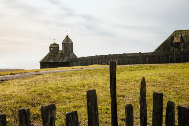 Brown wooden fence on green grass field during daytime