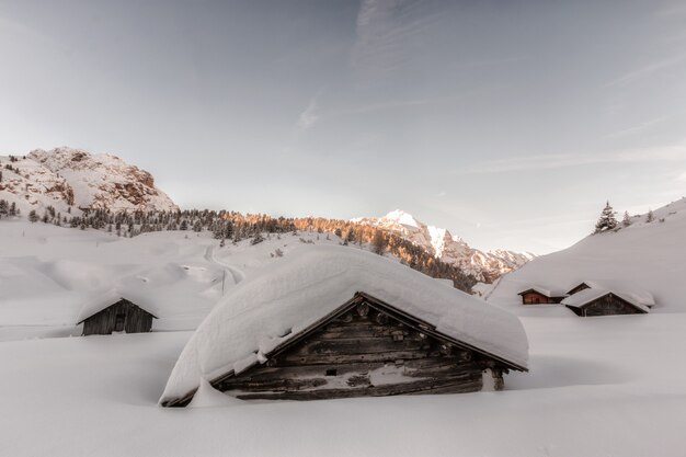 昼間は雪に覆われた茶色の木造住宅