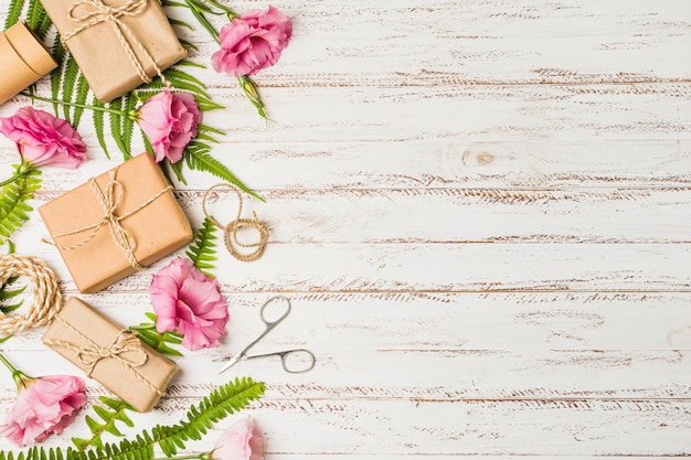 Brown wrapped gift box and pink eustoma flower over textured background