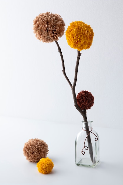 Brown and yellow pom poms in bottle