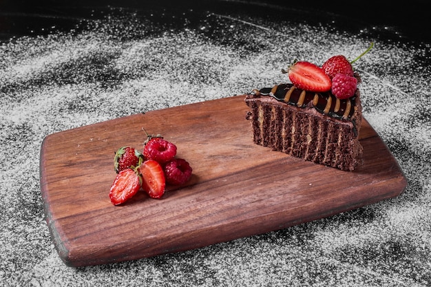 Brownie cake slice on a wooden platter .