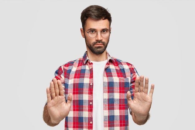 Brunet man wearing round eyeglasses and colorful shirt