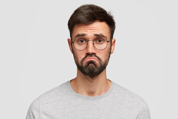 Brunet man wearing round eyeglasses and gray T-shirt