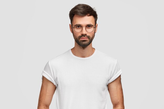 Brunet man wearing round eyeglasses and white T-shirt