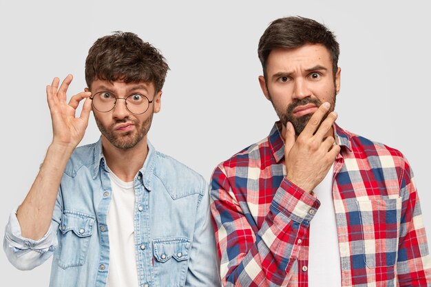 Brunet men wearing shirts and posing