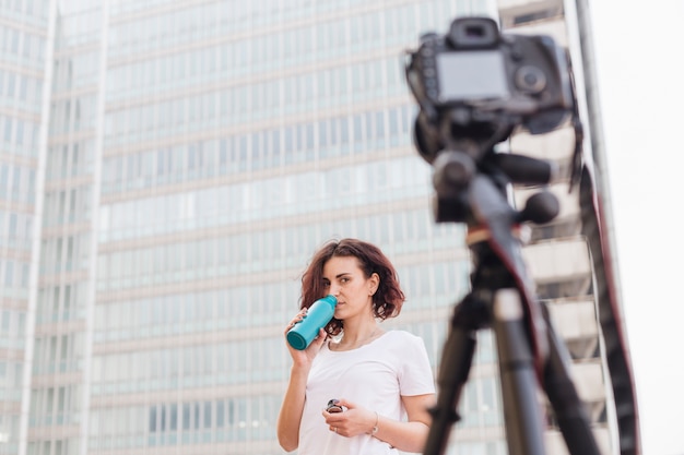 Бесплатное фото Брюнетка блоггер пьет воду из бутылки