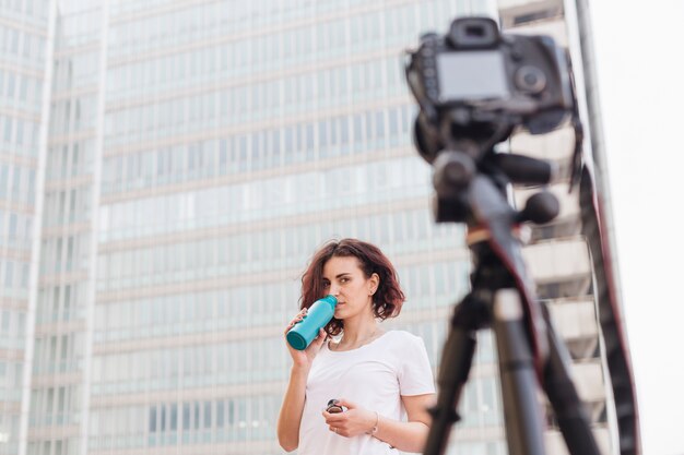 Brunette blogger drinking water from a bottle