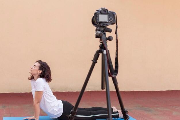 Brunette blogger recording yoga routine