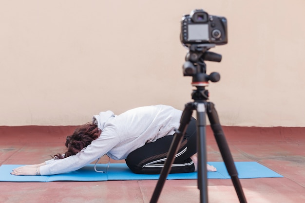 Brunette blogger recording yoga routine