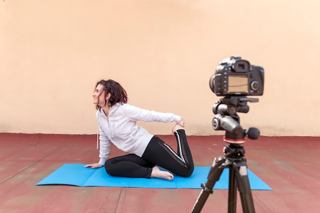 Foto gratuita blogger bruna che registra la routine di yoga