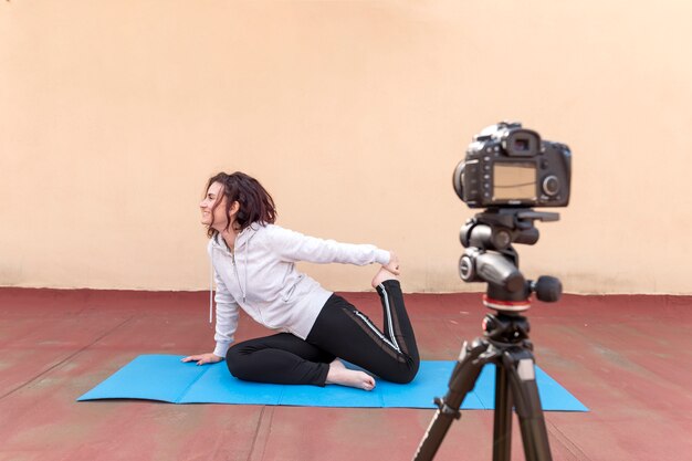 Brunette blogger recording yoga routine