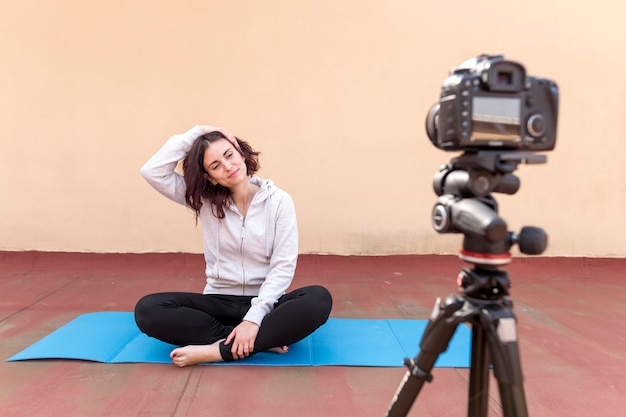 Brunette blogger recording yoga routine