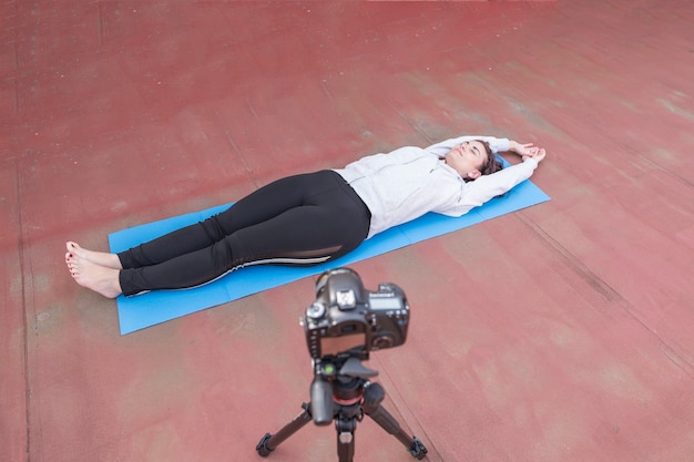 Foto gratuita blogger bruna che registra la routine di yoga