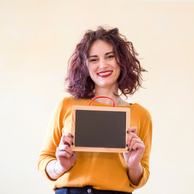 Brunette blogger showing blackboard to the camera