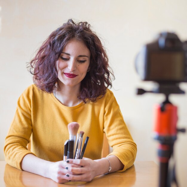 Brunette blogger showing make up brushes