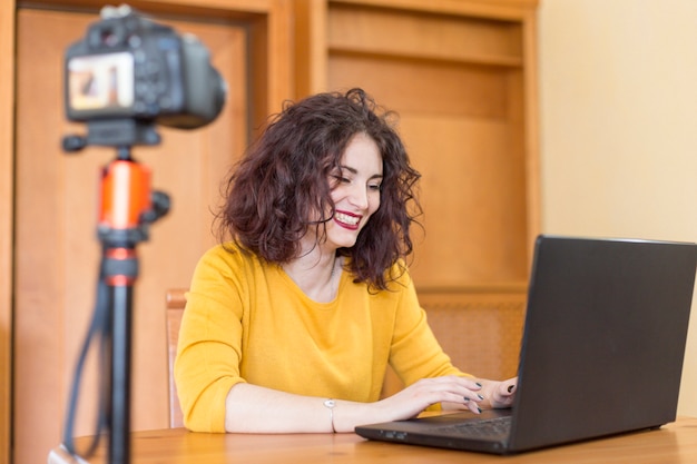 Brunette blogger writing on the laptop