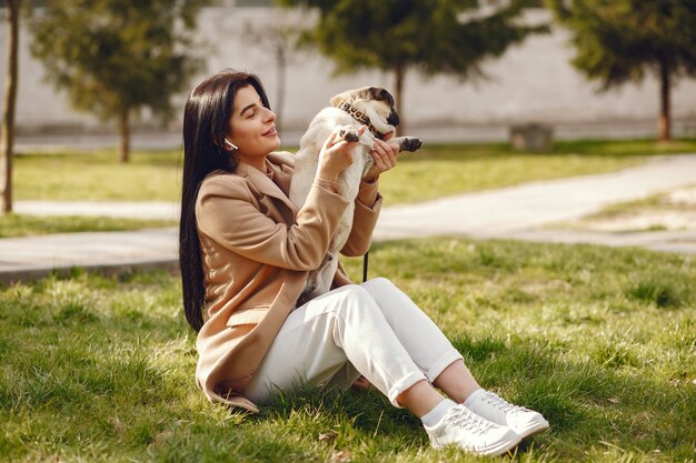 Brunette in a brown coat walks with pug