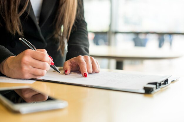 Brunette businesswoman writing on a document