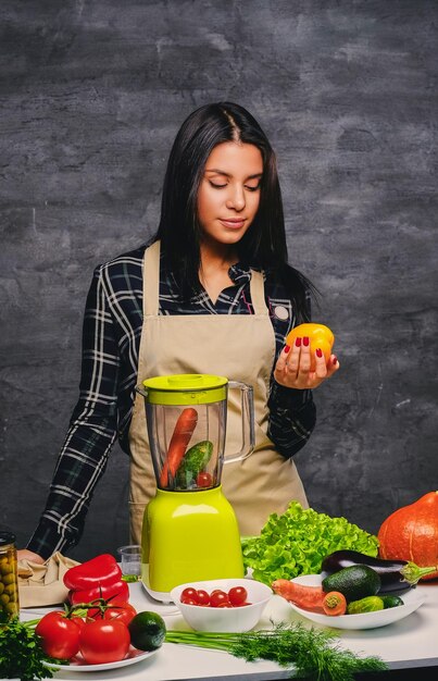 Brunette chef female cook at the table preparing vegan meals.