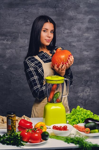 Brunette chef female cook at the table preparing vegan meals.