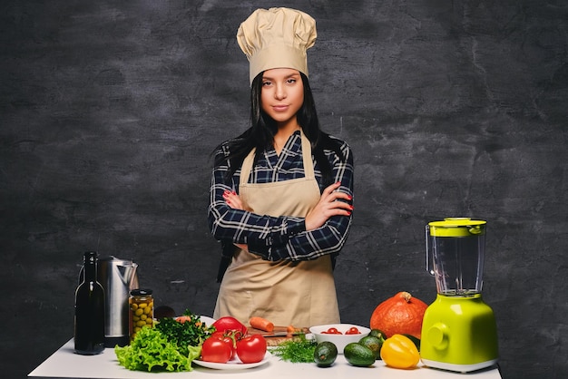 Cuoco femminile dello chef bruna al tavolo che prepara pasti vegani.