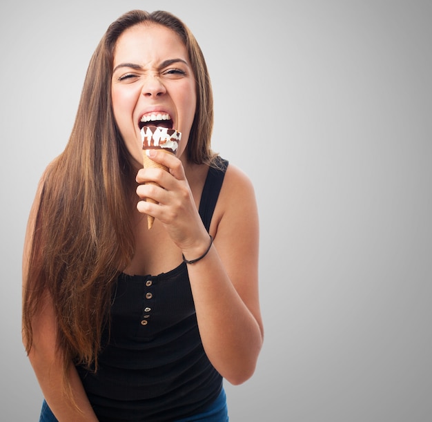 Brunette girl biting tasty ice cream