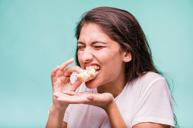 Brunette girl eating pastry