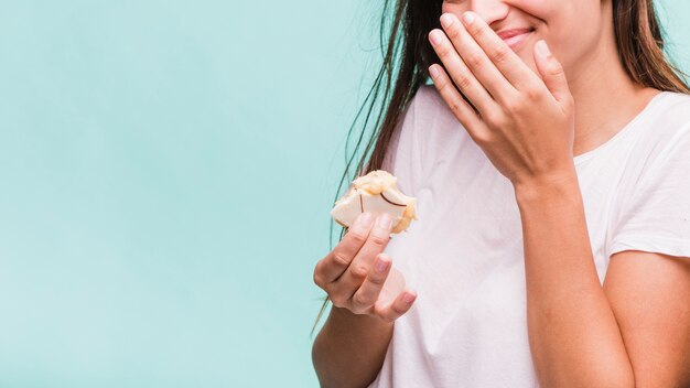 Foto gratuita ragazza bruna che mangia pasticceria