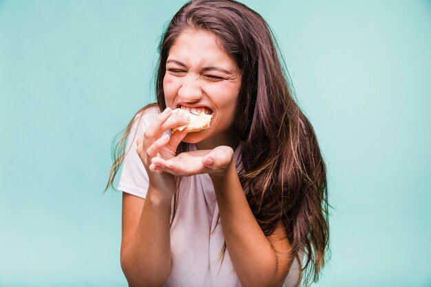 Brunette girl eating pastry